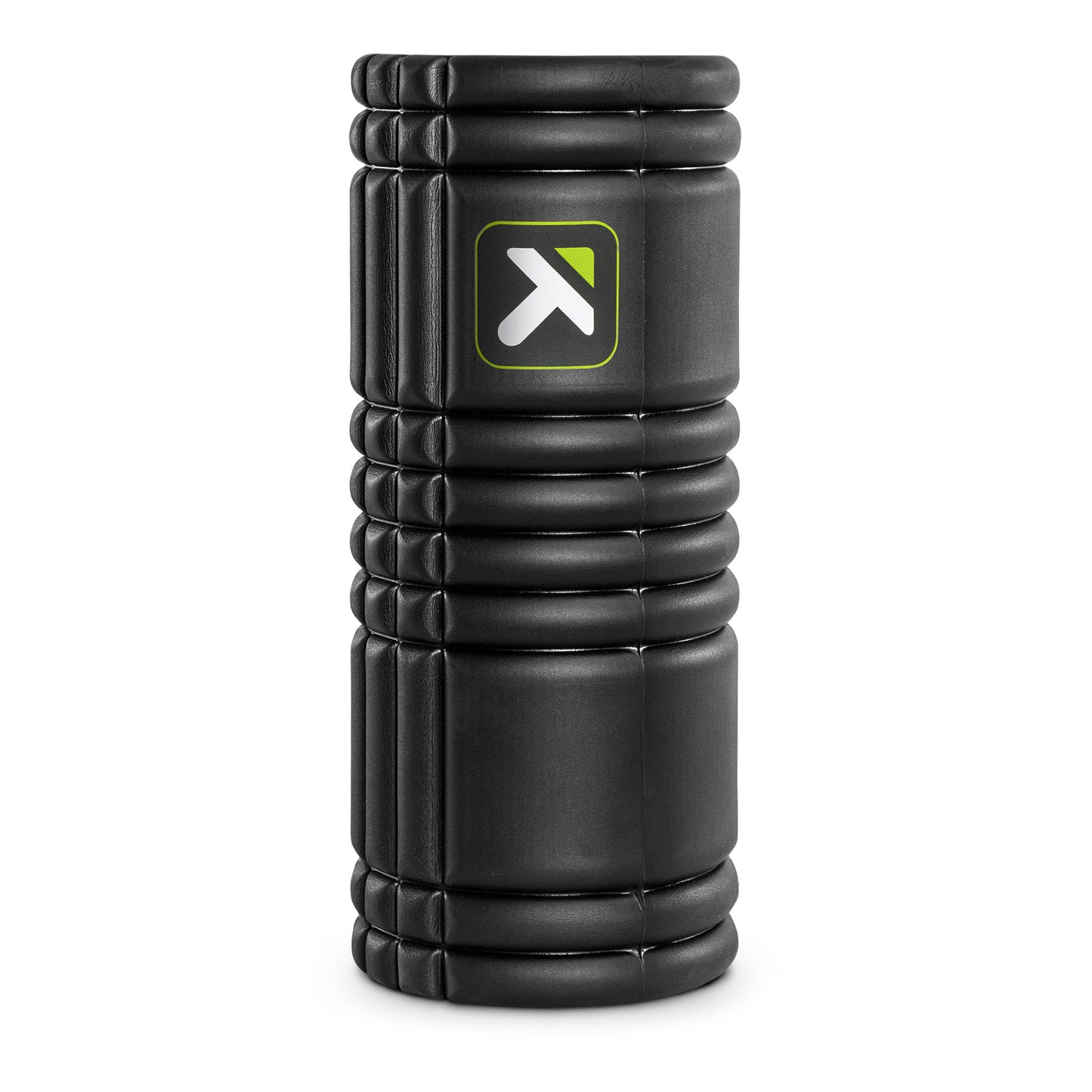 A black foam roller is placed upright in a studio setting.