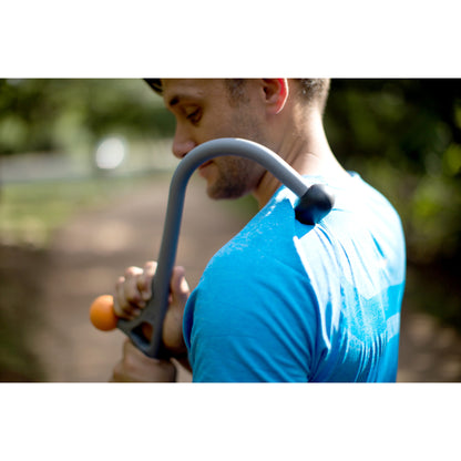 Runner holding a sledgehammer outdoors in a natural setting at a park or trail.