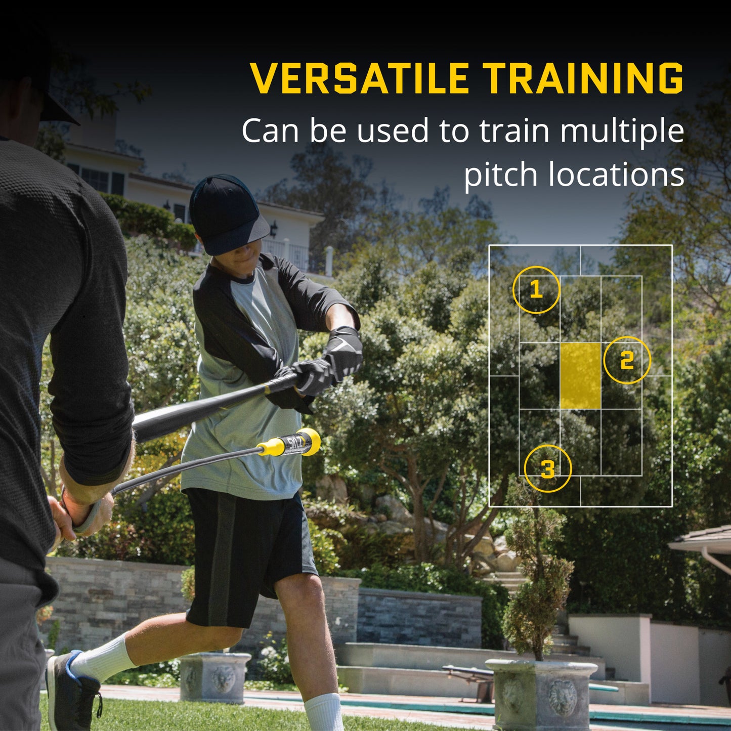 Two people practice golf training with a club outdoors near a garden and residential area