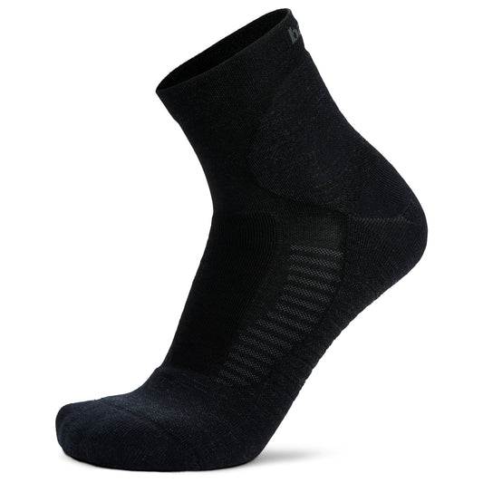 Black sock stands upright on white backdrop, showing fabric texture and ankle height.