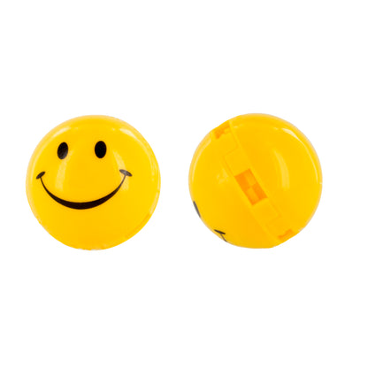 Smiley face ball rolls on a white surface.