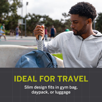 Man holds item beside blue bag, sitting outdoors near basketball court.