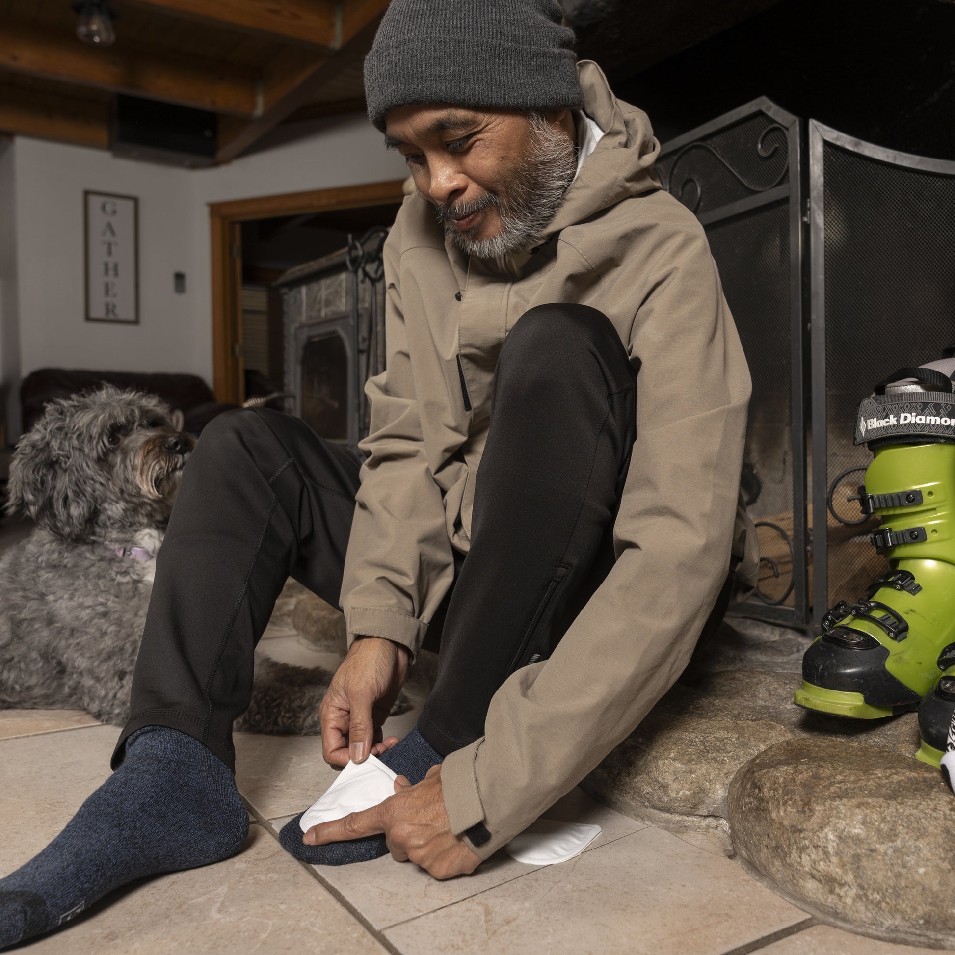Man shoes his dog after skiing indoors with paw in shoe at home