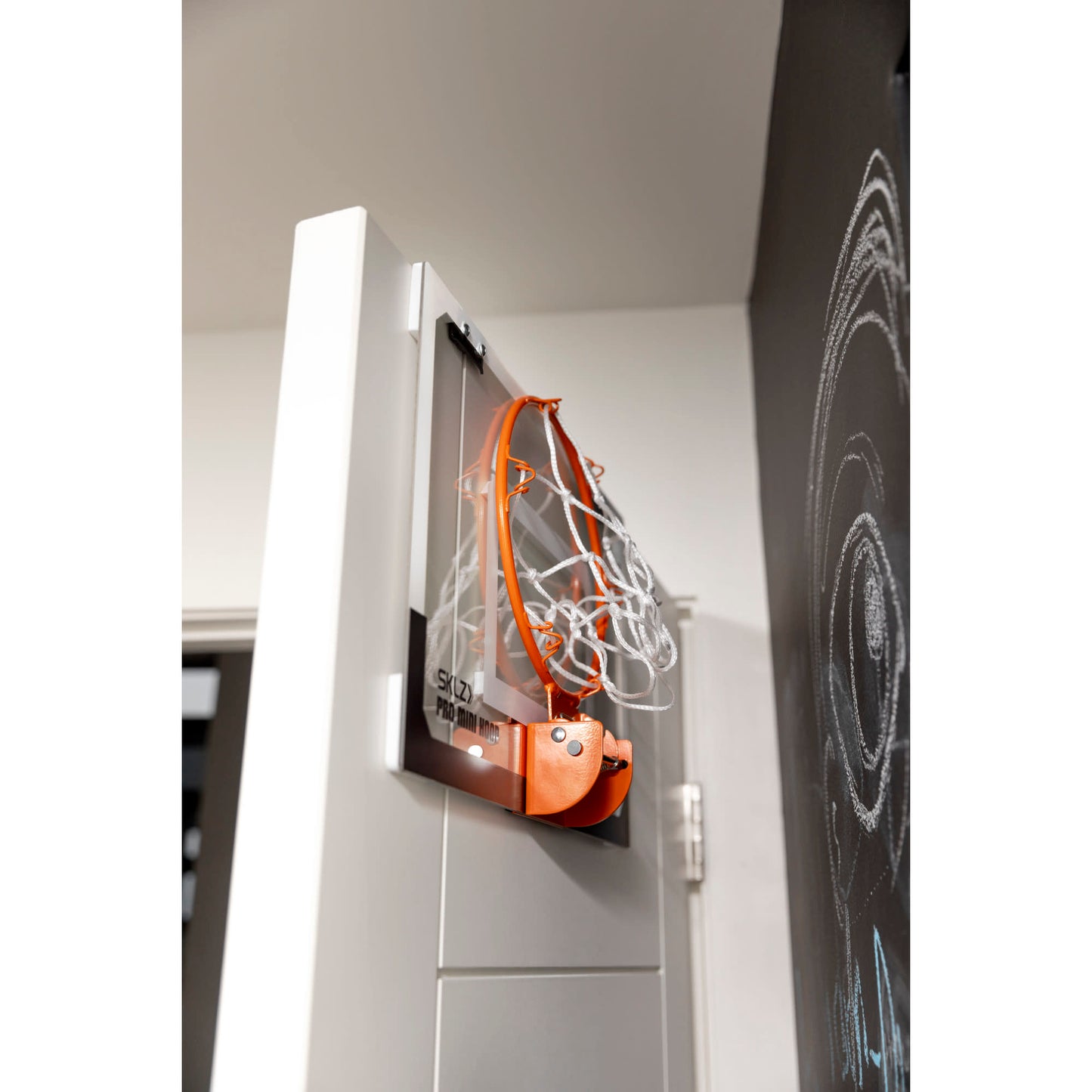 A sports ball retriever is mounted on a wall in a room with a chalkboard.
