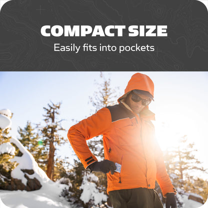A person wearing an orange jacket and sunglasses places a card into a pocket outdoors in winter