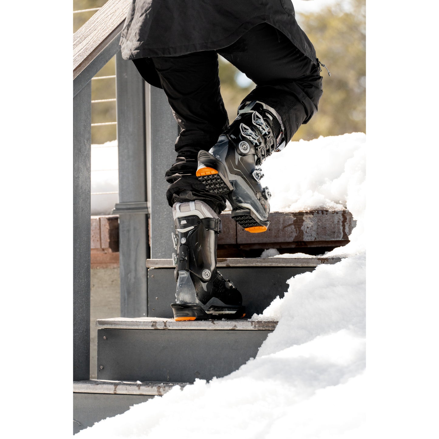 Person puts on ice skates on snowy outdoor stairs
