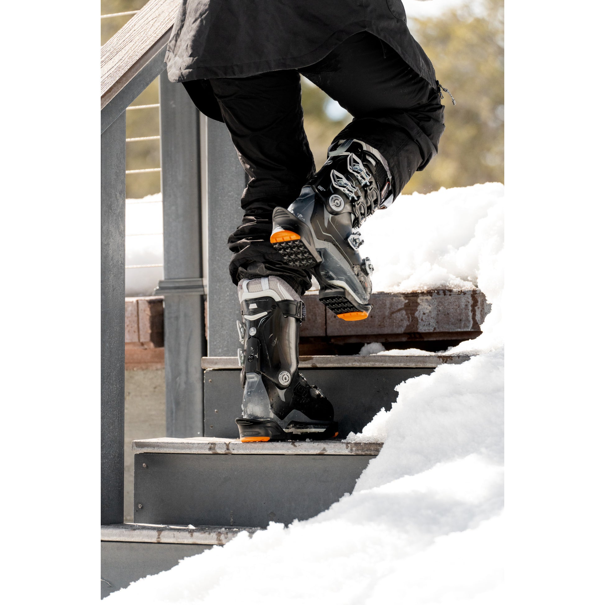 Person puts on ice skates on snowy outdoor stairs