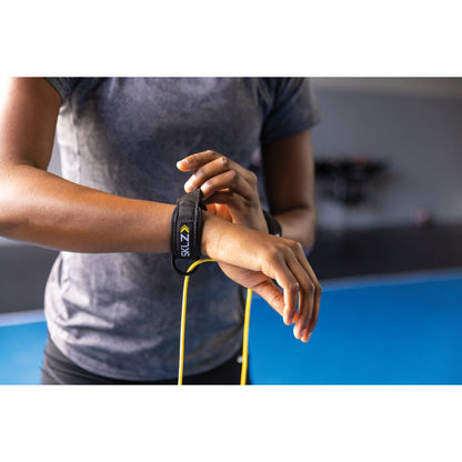 Close-up of SKLZ Bump and Pass Trainer being adjusted on female wrist in gym