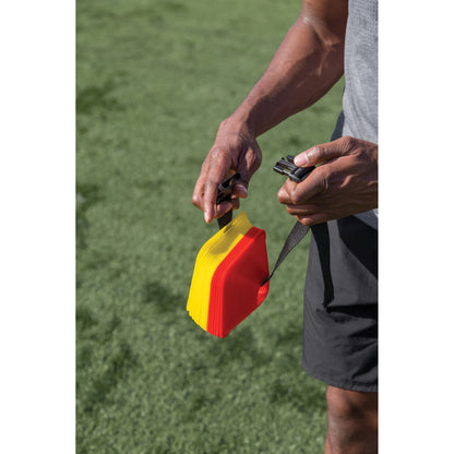 Person holds a stopwatch and whistle on a football field for timing and signaling