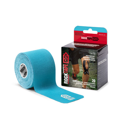 The roll of athletic tape is displayed near its box in an outdoor sports setting.