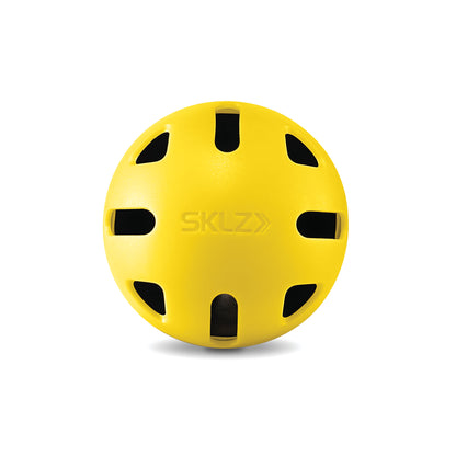 A yellow helmet with ventilation holes is placed on a white background