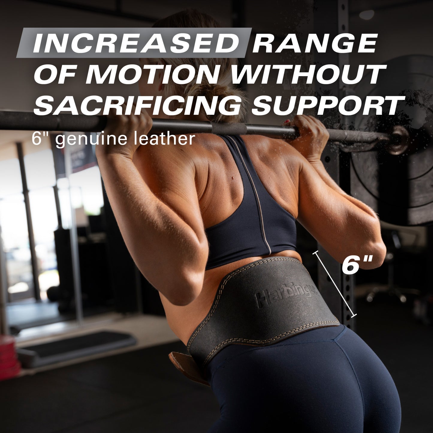 Weightlifter wears leather belt lifting barbell in gym.