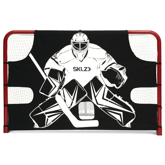 The goalie mask and pads block a goal in a hockey net on an ice rink
