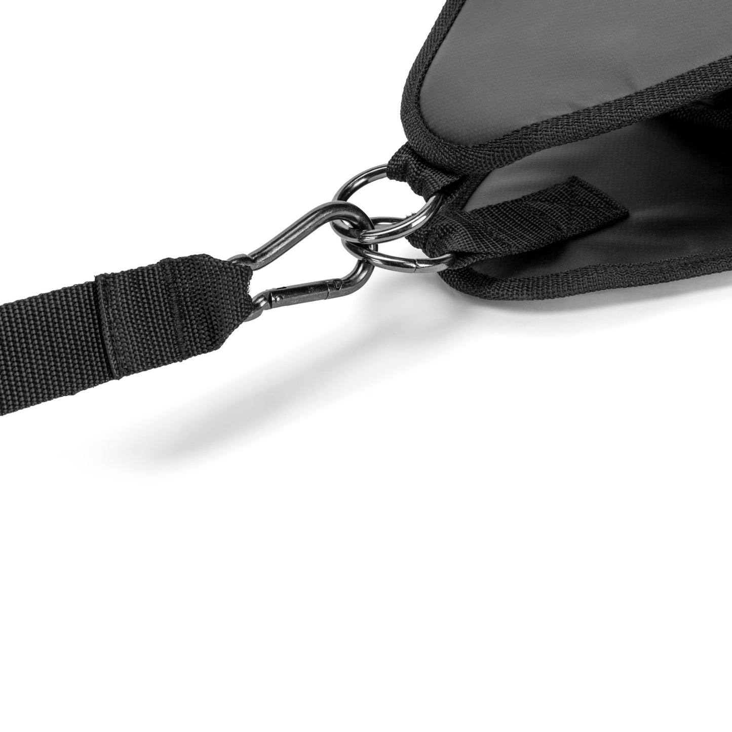 A strap secures a bag with metal hooks in a travel or outdoor environment