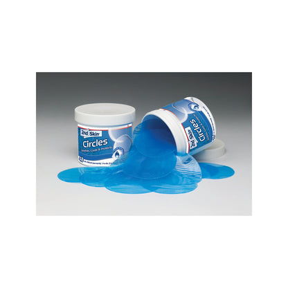 A container of bath bombs is spilled causing blue gel to flow onto a flat surface in a gray environment