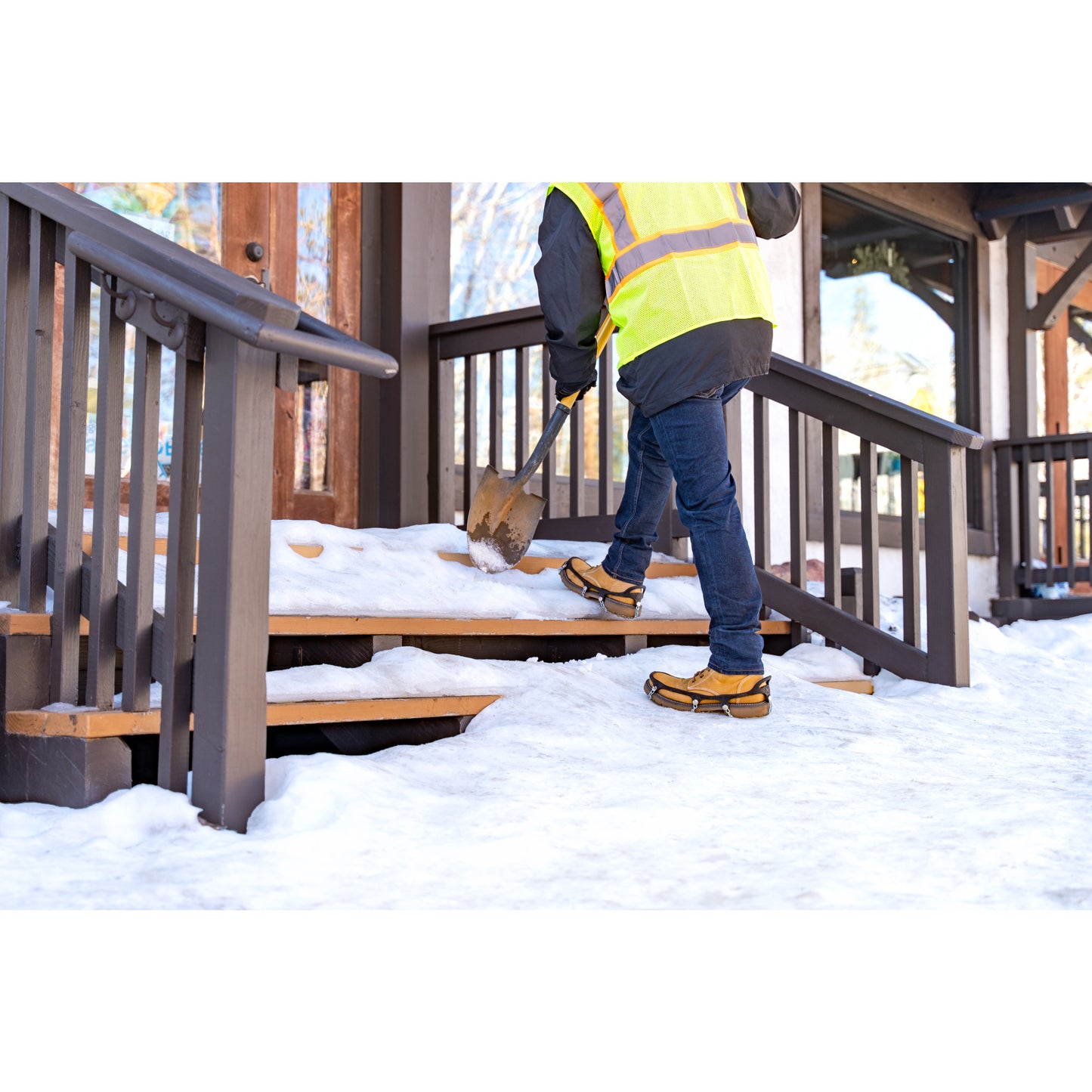 Child shoveling snow from stairs outdoors during winter